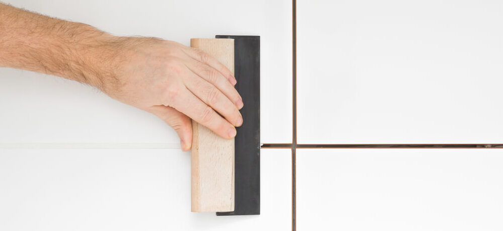 Imagem de uma pessoa assentando porcelanato.