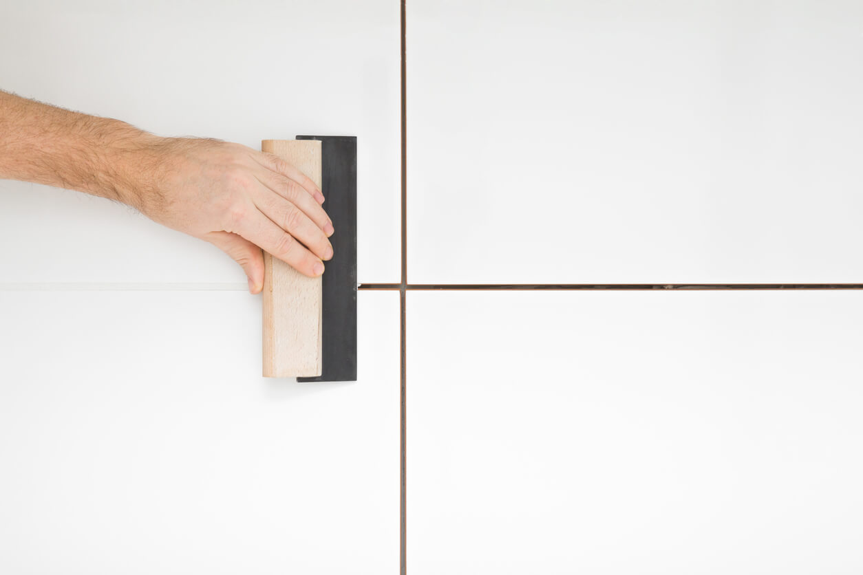 Imagem de uma pessoa assentando porcelanato.
