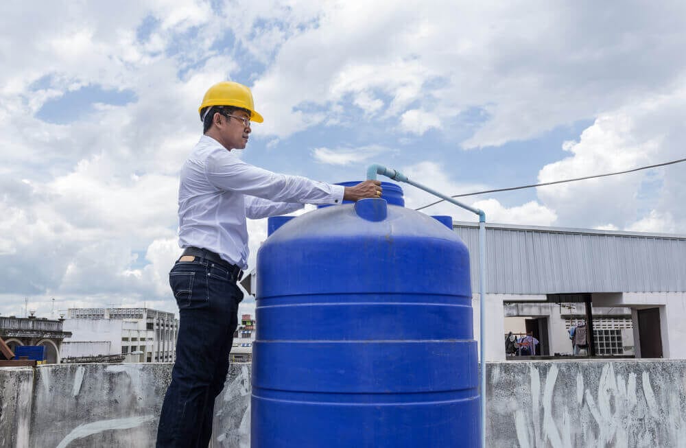 Profissional mexendo em caixa d'água em uma laje