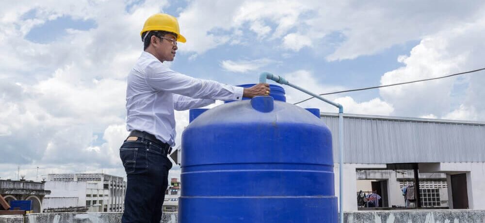Profissional mexendo em caixa d'água em uma laje