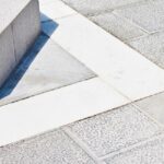 Imagem de uma calçada de concreto com detalhes brancos no piso