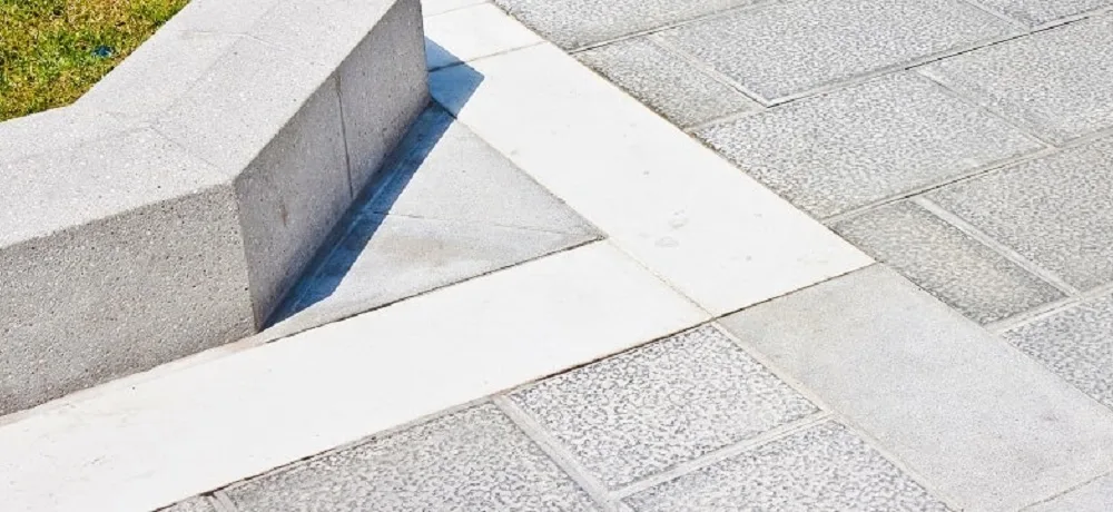 Imagem de uma calçada de concreto com detalhes brancos no piso