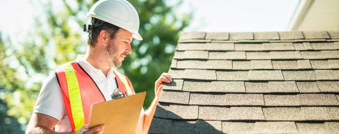 Profissional em obra conferindo a inclinação do telhado.