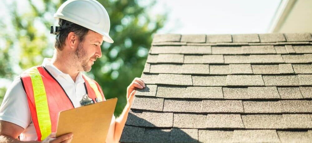 Profissional em obra conferindo a inclinação do telhado.
