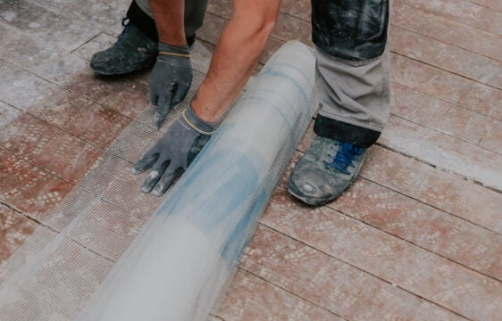 Profissional aplicando malha impermeabilizante em área externa