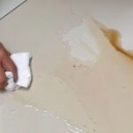 Pessoa tentando tirar mancha de piso cerâmico