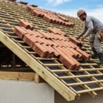 Profissional mostrando como instalar telhas em telhado residencial com telhas cerâmicas
