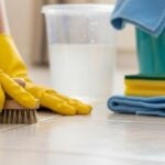 Pessoa mostrando como limpar rejunte encardido com esponja