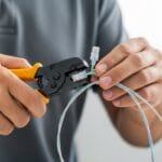 Técnico mostrando como crimpar cabo de rede