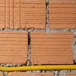Eletroduto corrugado amarelo instalado em parede de alvenaria