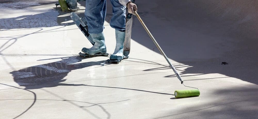 Profissional realizando impermeabilização de piscina